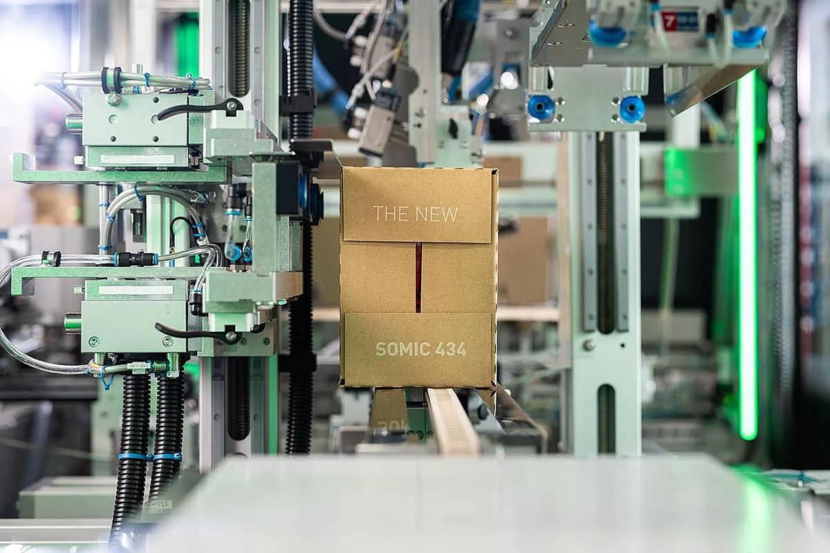 somic-434-endverpackungsmaschine-kartonauslauf-1200x800 Ein fertig verpackter Wraparound-Karton verlässt die SOMIC 434 Endverpackungsmaschine